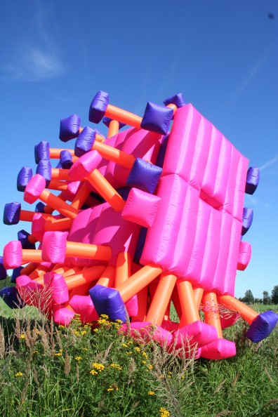 Pink inflatable suit smashing through flowers and grass
