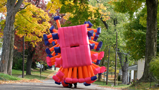Jimmy Kuehnle's inflatable suit bounding down a street of fall leaves