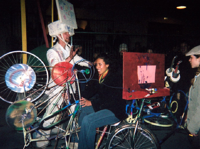 An audience member using a meta matic drawing machine attached to a bicycle.