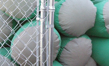 Inflatable suit passes by a chain link fence