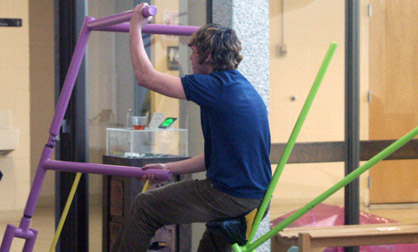 Wenatchee Valley College student pedaling out of the gallery on a bike
