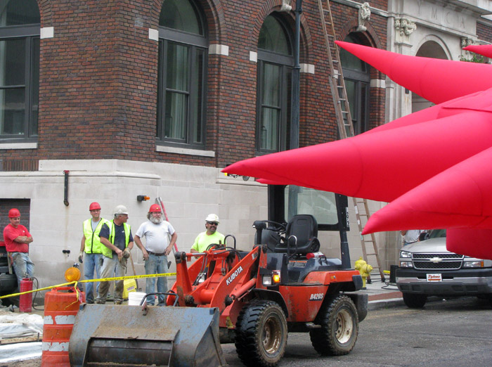 Construction workers in Grand Rapids stare at an inflatable suit